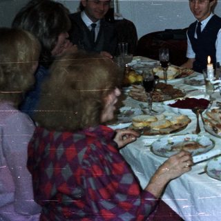 Family gathered around a large table enjoying a meal.