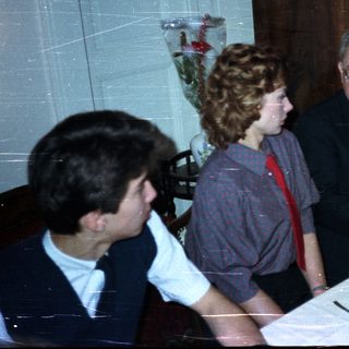 Here's a brief summary of the image: Three people seated at a table with glassware.
