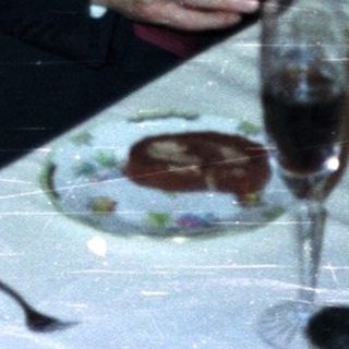 Here's a brief summary of the image: Three people seated at a table with glassware.