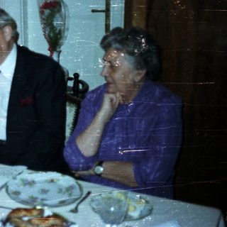 Couple and dog at a formally set dinner table.