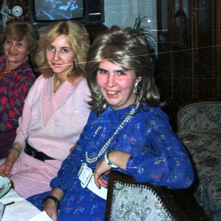 Three women seated at a table in a dimly lit room.