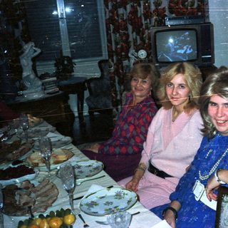 Three women seated at a table in a dimly lit room.