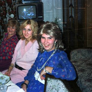 Three women seated at a table in a dimly lit room.