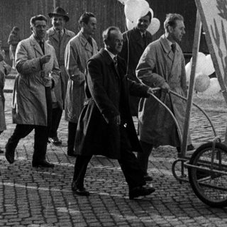 Men parade a May Day banner with balloons.