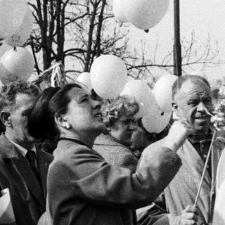 Group gathers, holding balloons; likely a celebration or event.