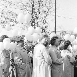 Group of people with balloons in a black and white photo.