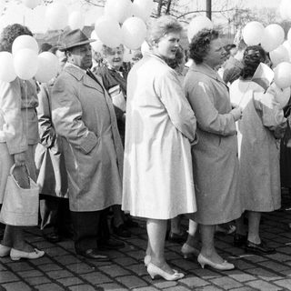 Group of people with balloons in a black and white photo.