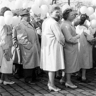 Group of people with balloons in a black and white photo.