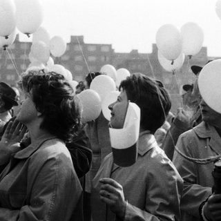 People release balloons during a gathering, likely celebratory.