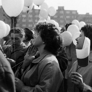 People release balloons during a gathering, likely celebratory.