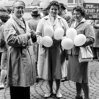 Three people hold balloons in a black and white photo.