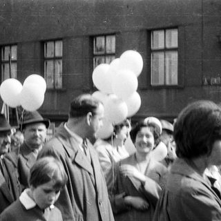 Group of people holding balloons, black and white photograph.