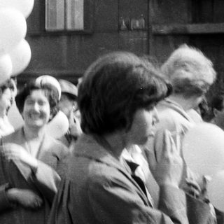 Group of people holding balloons, black and white photograph.