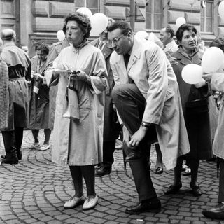 People watch as balloons float during a public gathering.