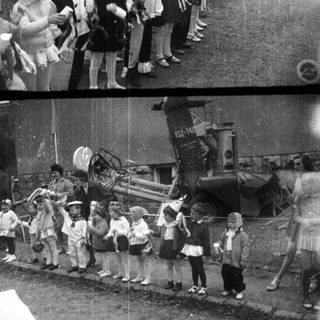 Children stand near a tractor at an event.