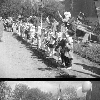 Children march past a vehicle, possibly in a parade.