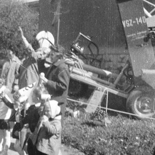 Children march past a vehicle, possibly in a parade.