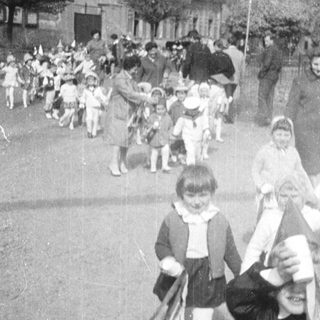 Group of children marching down a paved road.