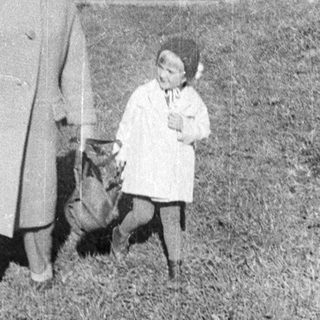 Here's a brief summary of the image: Three figures walk along a grassy path.