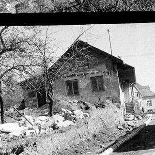 Here's a brief summary of the image: Houses on a hillside, construction site, and trees.
