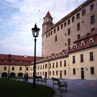 Large, historic castle complex with surrounding buildings and gardens.