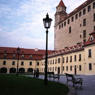 Large, historic castle complex with surrounding buildings and gardens.