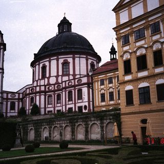 Ornate Baroque church and building complex in a garden.