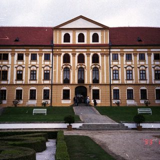 Elegant palace facade with a symmetrical garden and steps.
