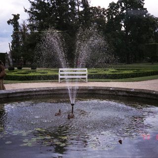 Fountain in a formal garden with people observing.