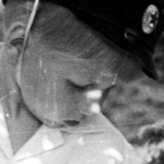 Boy in hat stands near a table outdoors.