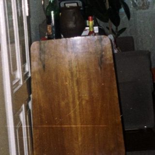 Man stands in kitchen, viewed through doorway with decor.