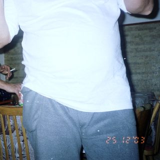 Man in white shirt stands near person smoking indoors.