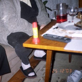 Two people seated on a couch, drinks and food nearby.
