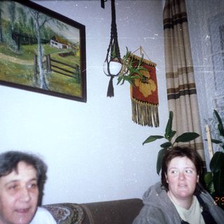 Two women are seated in a room with artwork.
