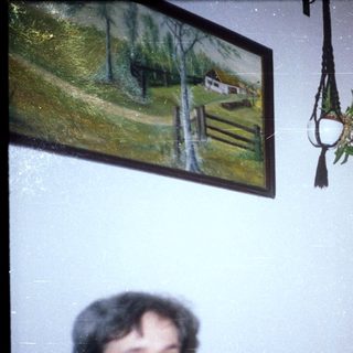 Two women are seated in a room with artwork.