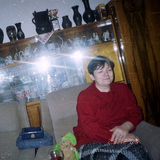 Man sits near a Christmas tree in a room.