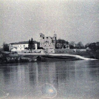 Castle overlooking a river, captured in a vintage photograph.