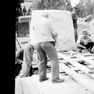 Men working with lumber on a flatbed truck.
