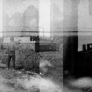 Here's a brief summary of the image: Blurred scene with a person, foliage, and a vehicle.