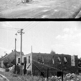 Dilapidated brick building next to a well-kept house.
