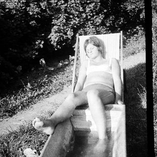 Here's a brief summary of the image: Two black and white photos show people relaxing outdoors.