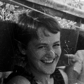 Four children smiling on a rooftop, black and white photo.