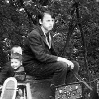 Man and children in a carriage being pulled by a horse.