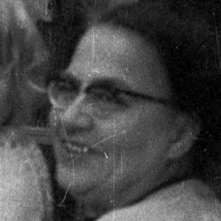 Woman holding a baby near an enclosure.