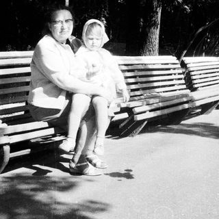 Woman and child seated on a park bench.