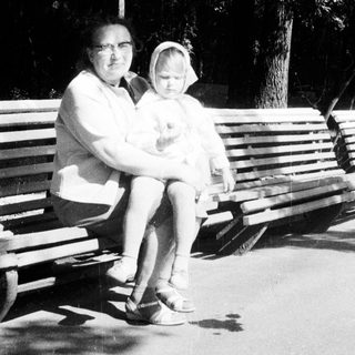 Woman and child seated on a park bench.