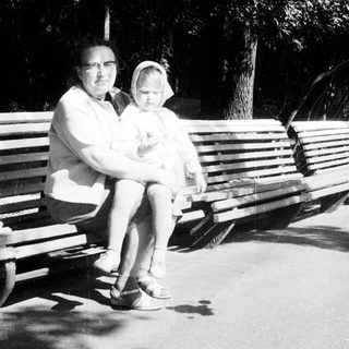 Woman and child seated on a park bench.