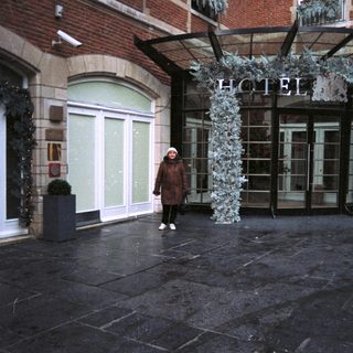 Woman stands outside a decorated hotel entrance.