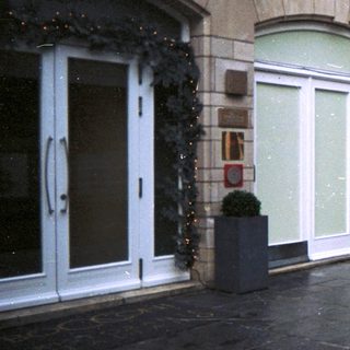 Woman stands outside a decorated hotel entrance.