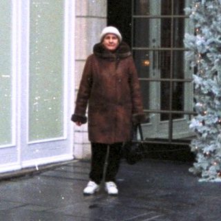 Woman stands outside a decorated hotel entrance.